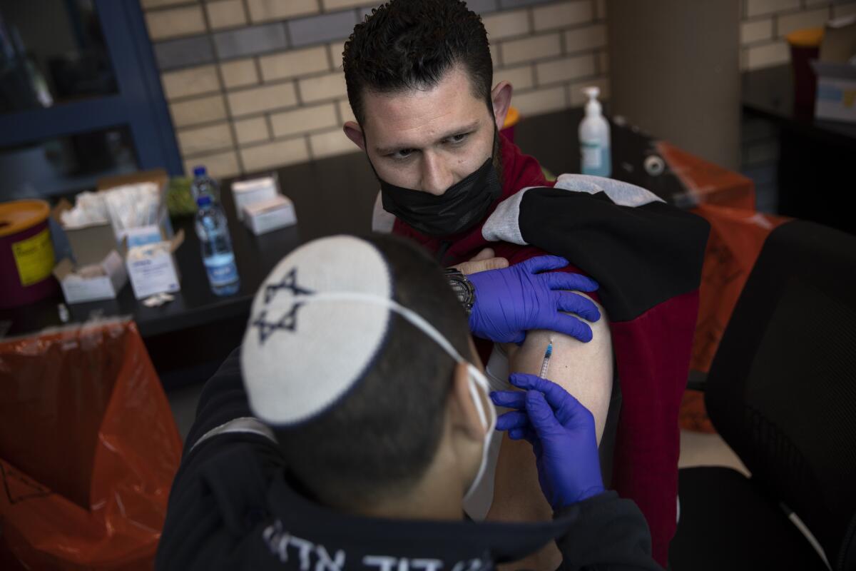 Israeli medical teams administer the Pfizer-BioNTech COVID-19 vaccine to Palestinians at the Qalandia checkpoint