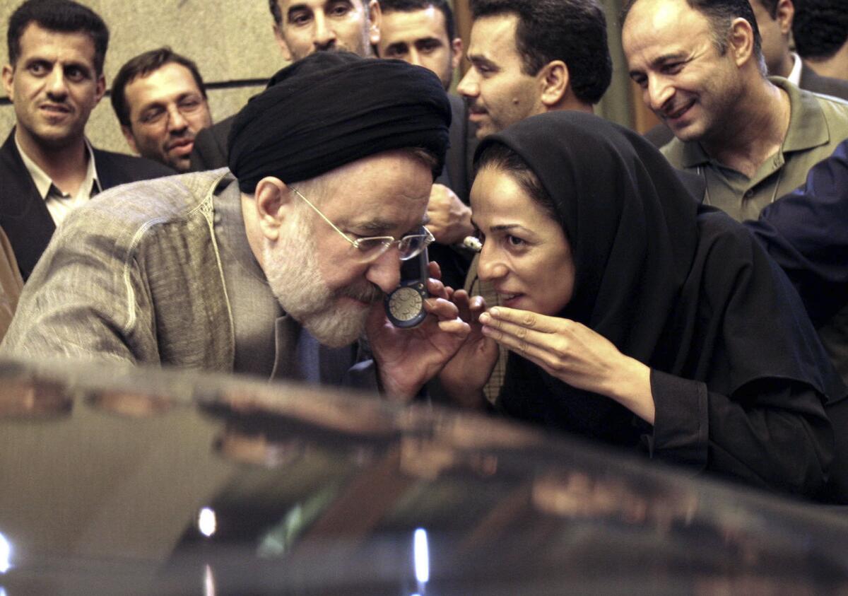 FILE - In this July 13, 2005, file photo, outgoing reformist Iranian President Mohammad Khatami talks on the phone with the mother of female journalist Masih Alinejad, right, after meeting with journalists in Tehran, Iran. Prosecutors in the U.S. alleged Tuesday, July 13, 2021, that Iran planned to kidnap Alinejad, famous for her campaign against the Islamic Republic's mandatory headscarf, or hijab, for women. Iran did not immediately comment on the allegation Wednesday, July 14, 2021. (AP Photo/Hasan Sarbakhshian, File)