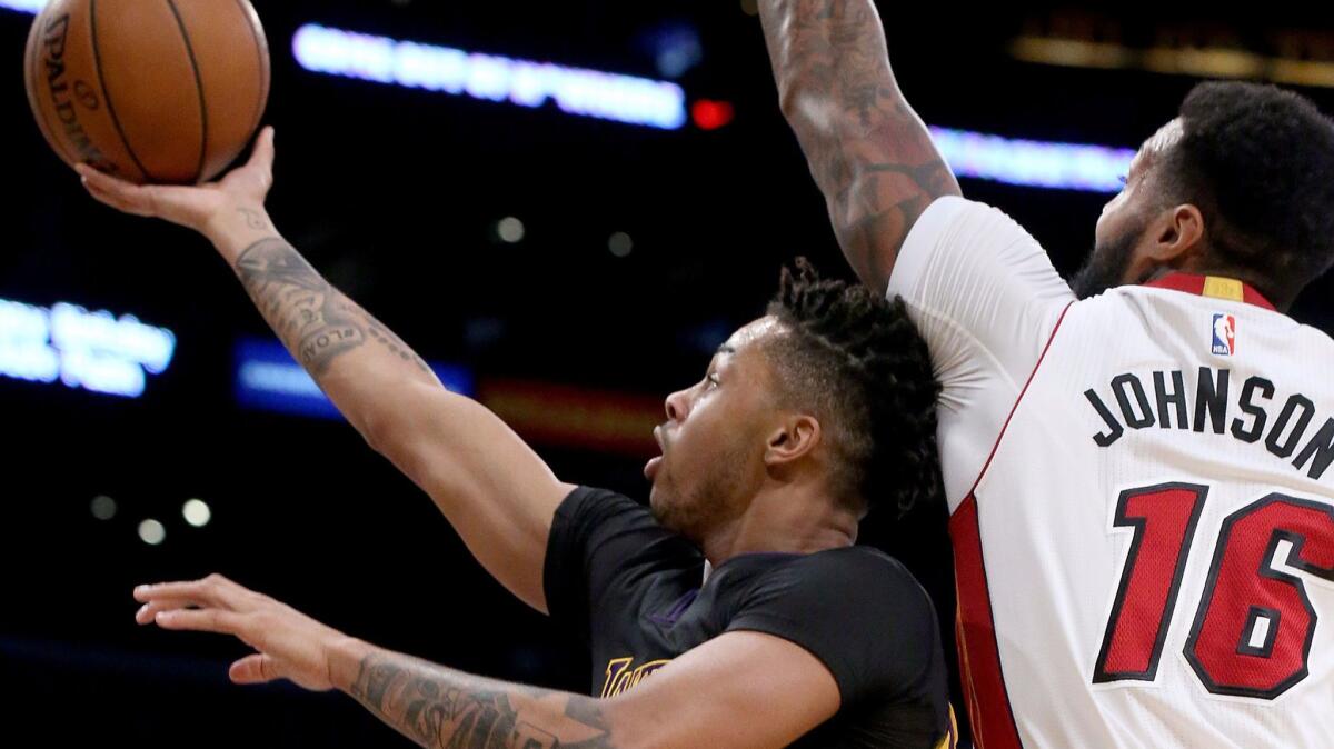 Lakers guard D'Angelo Russell drives past Heat forward James Johnson for a basket during the first quarter Friday night.