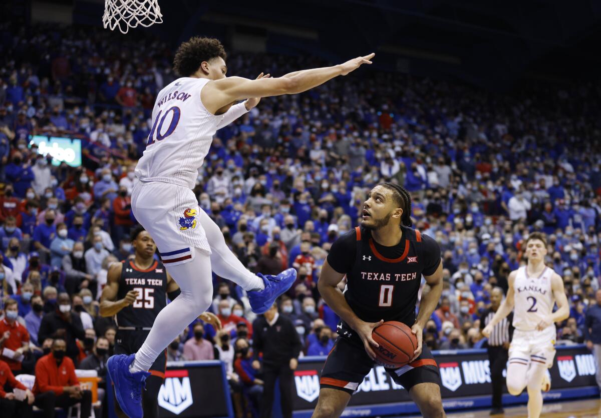 Kansas forward Jalen Wilson (10) blocks Texas Tech forward Kevin Obanor (0) from attempting to score during the second half of an NCAA college basketball game on Monday, Jan. 24, 2022, in Lawrence, Kan. (AP Photo/Colin E. Braley)