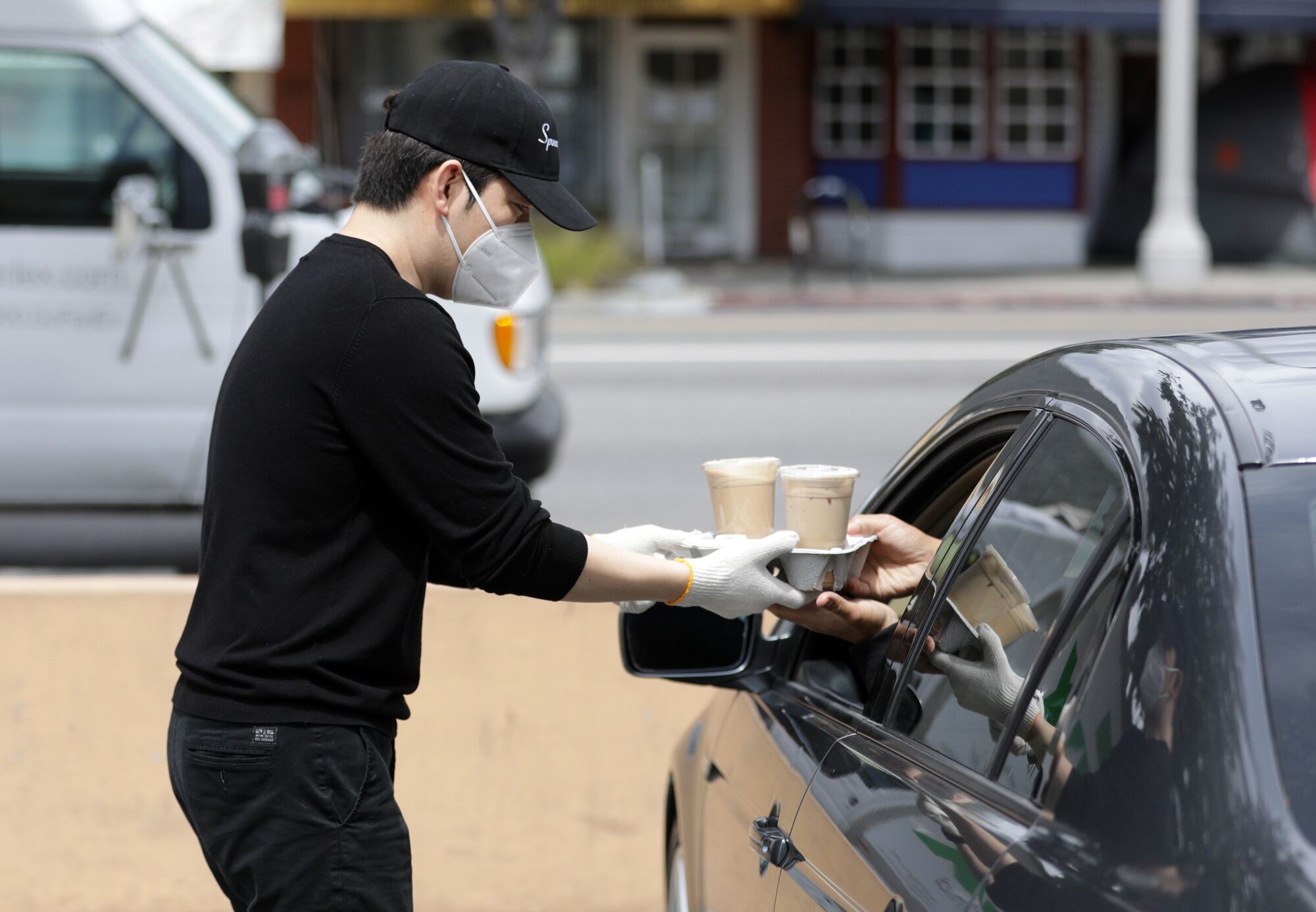 Joseph Hwang, manager of Spoon by H, hands drinks to a waiting customer.