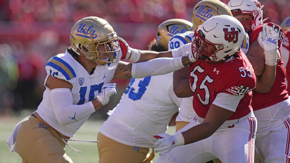 UCLA defensive lineman Laiatu Latu battles with Utah offensive lineman Spencer Fano.