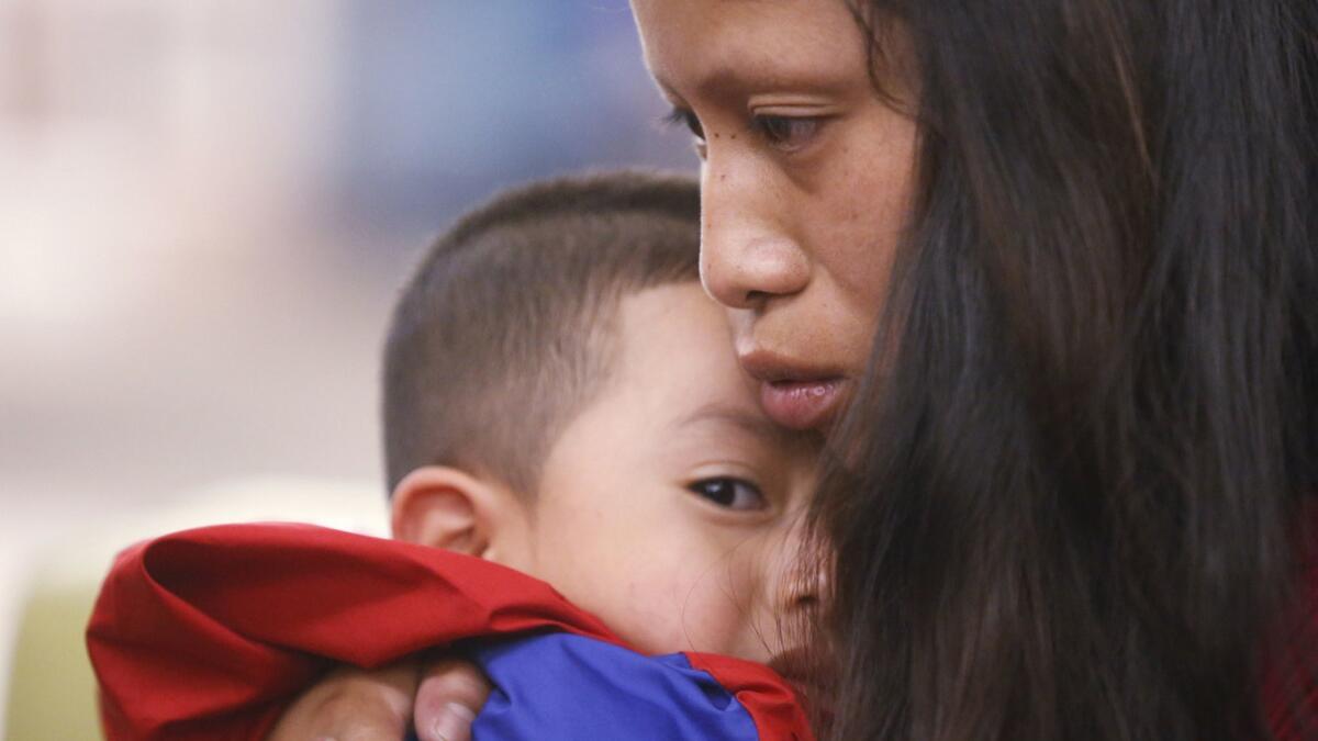 An immigrant holds her 4-year-old son after he arrived at the El Paso International Airport on July 26. They had been separated for six weeks.