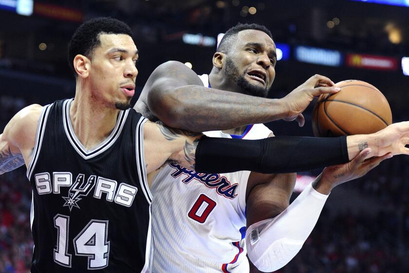 Clippers forward Glen Davis grabs a rebound before Spurs guard Danny Green can get to it in the first half of Game 1.