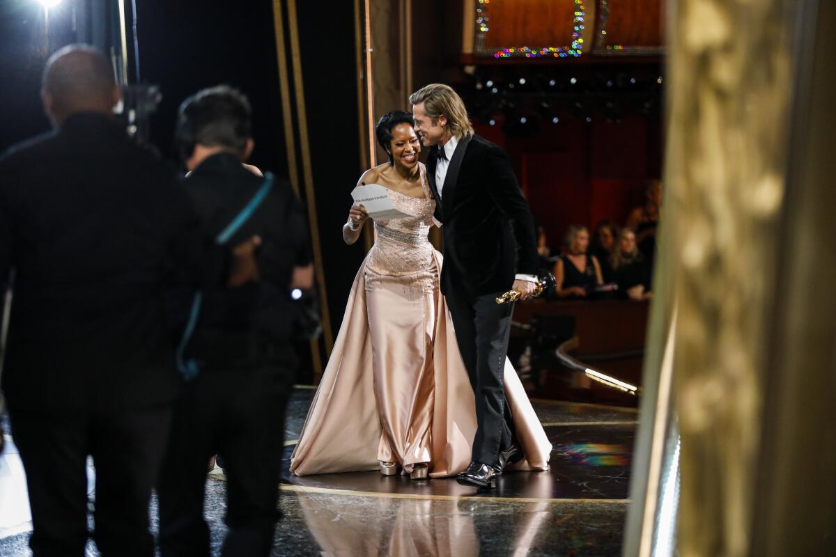 Brad Pitt, winner of the supporting actor Oscar for “Once Upon a Time...in Hollywood,” walks offstage with presenter Regina King.