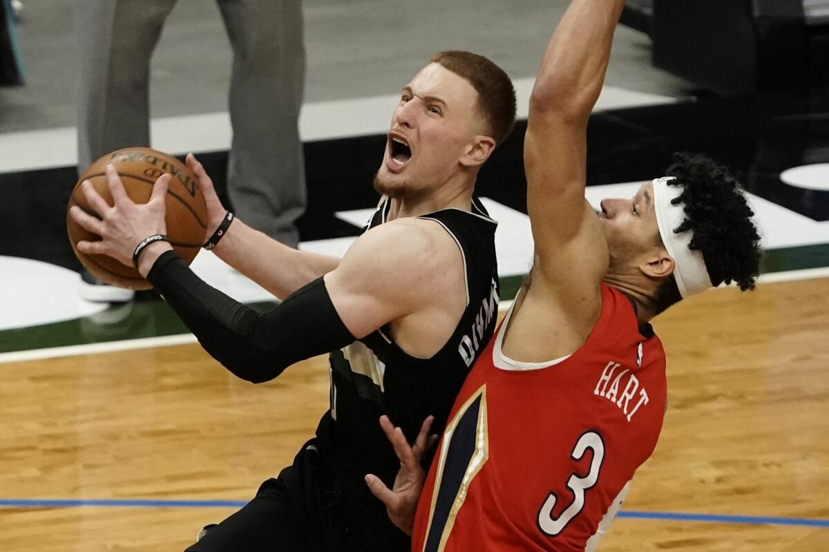 Milwaukee Bucks' Donte DiVincenzo shoots past New Orleans Pelicans' Josh Hart during the second half of an NBA basketball game Thursday, Feb. 25, 2021, in Milwaukee. (AP Photo/Morry Gash)