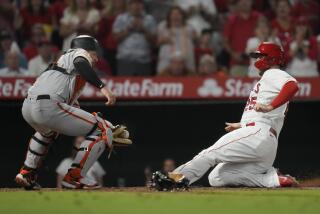 Los Angeles Angels' C.J. Cron (25) scores as San Francisco Giants catcher Patrick Bailey (14) drops a throw to home during the sixth inning of a baseball game in Anaheim, Calif., Monday, Aug. 7, 2023. (AP Photo/Ashley Landis)