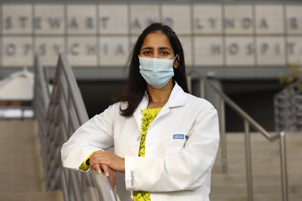 Dr. Ritu Salani leans against a rail on stairs outside Ronald Reagan UCLA Medical Center