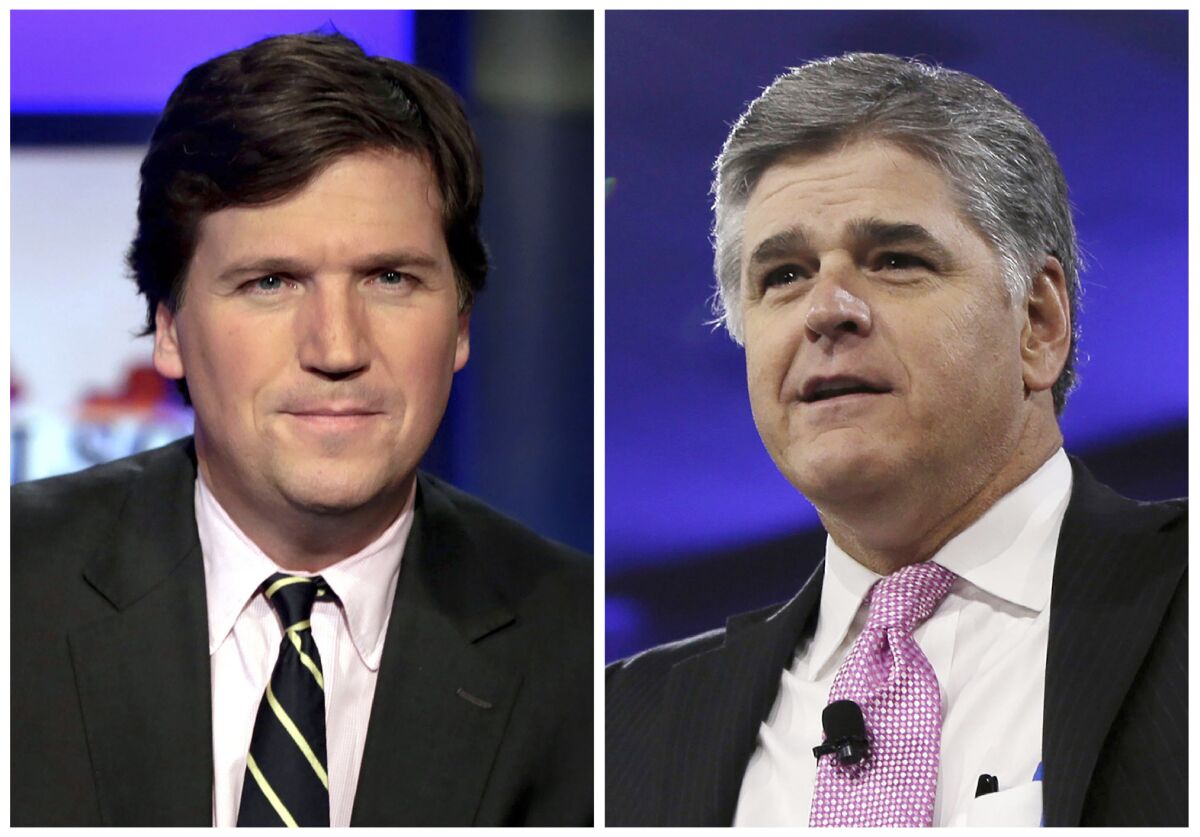 This combination photo shows, from left, Tucker Carlson, host of "Tucker Carlson Tonight," and Sean Hannity, host of "Hannity" on Fox News. Several conservative media figures in the United States, including Carlson and Hannity, have taken up the cause of Canadian truckers who have occupied parts of Ottawa and blocked border crossings to protest COVID-19 restrictions and vaccine mandates. (AP Photo/File)