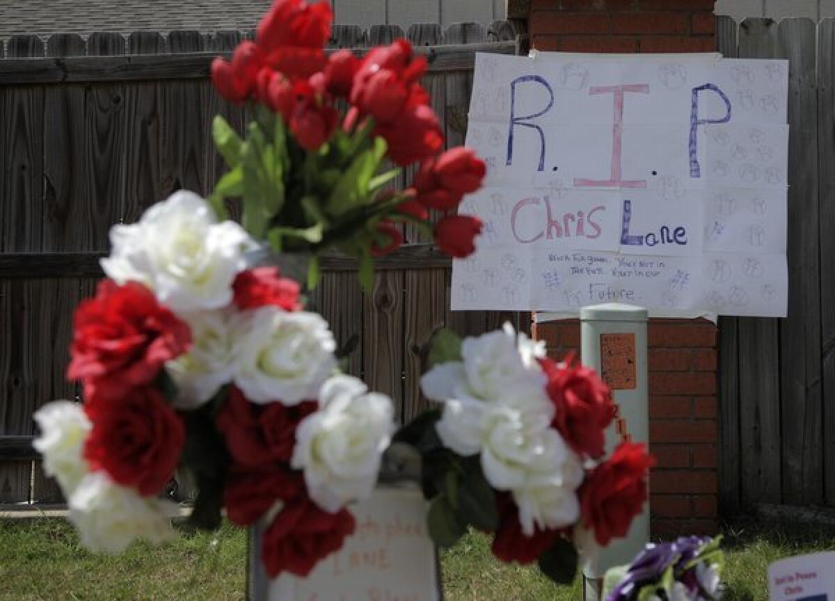 A sign hangs on a makeshift memorial for slain Australian college student Christopher Lane, 22, outside the neighborhood where he was killed in Duncan, Okla.