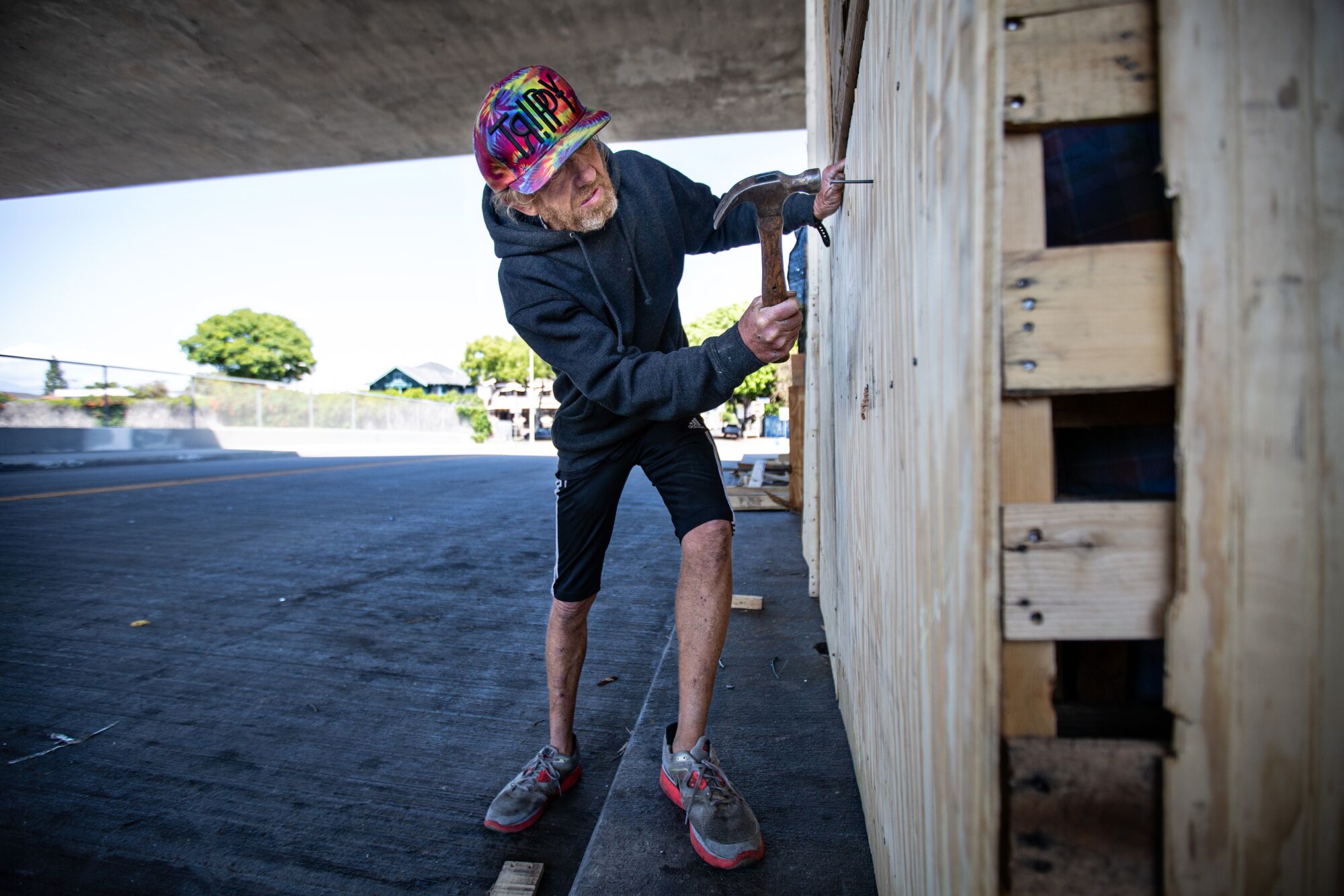 Kenny Welch, 57, of Los Angeles builds a living structure on a 110 Freeway overpass.
