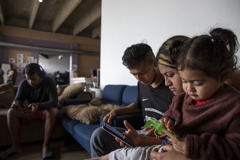 Tijuana , Baja California - May 11: Jeyson Martinez, 25, and Nicolle Urbina, 20, sit with their daughter Marlexy Martinez, 1, as they try to figure out the changes in the CBP One smartphone app at Espacio Migrante on Thursday, May 11, 2023 in Tijuana , Baja California. Title 42 was put in place by the Trump administration in March 2020 based on a public health order that was used to block migrants from entering the United States. The policy is expected to end at 11:59 p.m. Thursday. (Ana Ramirez / The San Diego Union-Tribune)