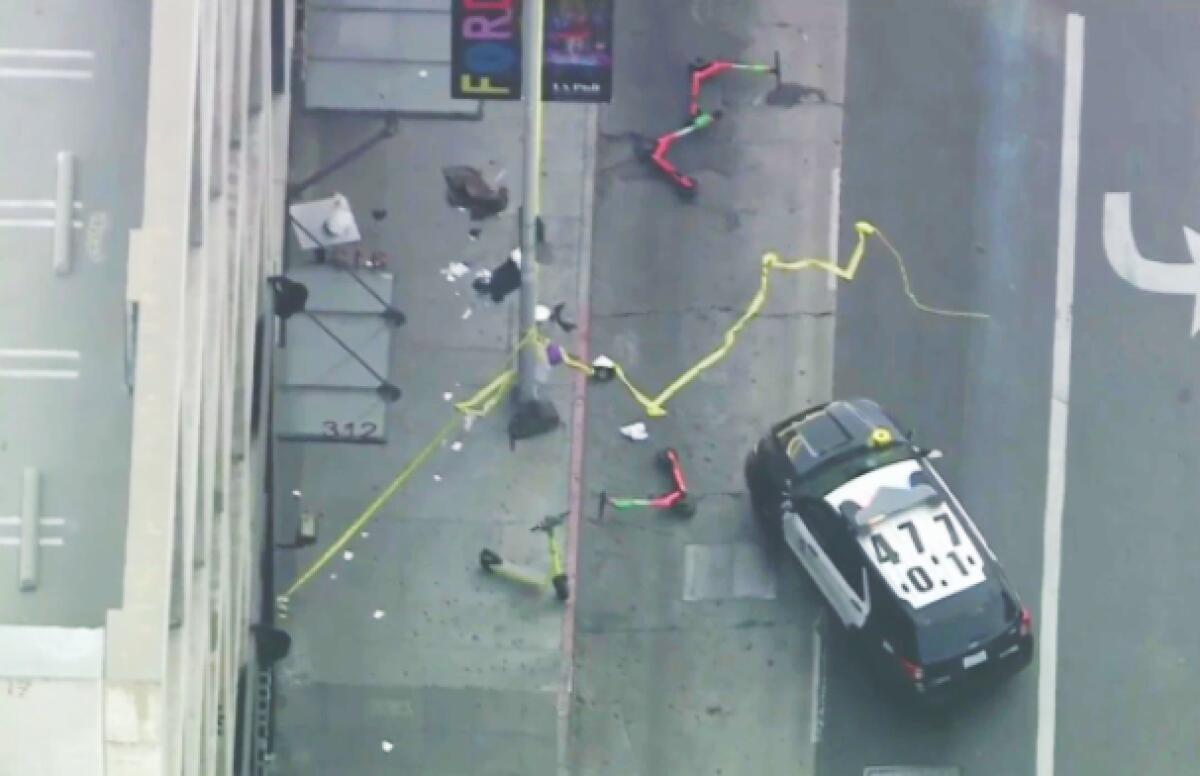 Aerial view of a police car, knocked-over scooters, and police tape