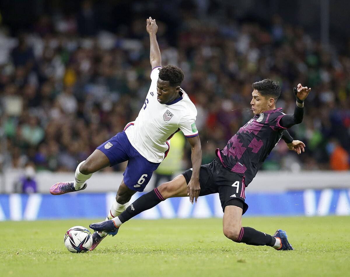 U.S. midfielder Yunus Musah, left, and Mexico midfielder Edson Alvarez battle for the ball.