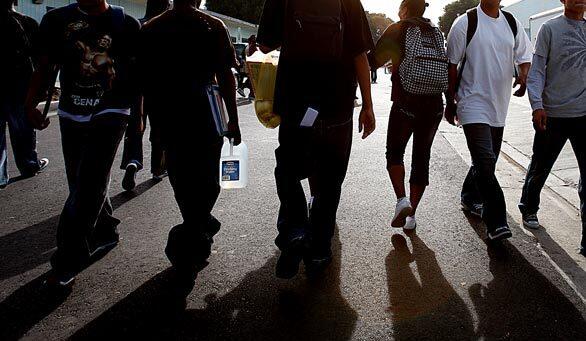 Students walk along Saints Way, a main thoroughfare on the campus of Locke High School in South Los Angeles. Come July 1, Locke will be the first L.A. school operated by a private organization, Green Dot Public Schools. It is also the first school to undergo a form of reconstitution, meaning that every staff member must reapply for their jobs. Most won't be returning.