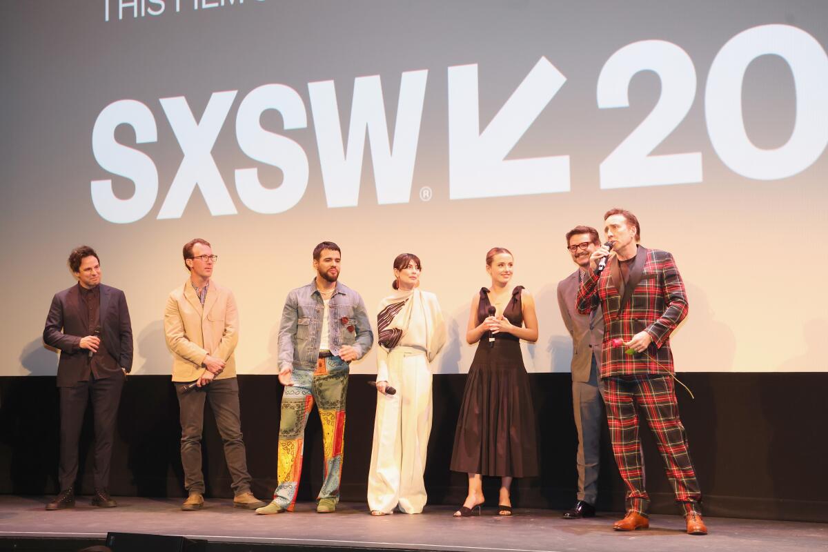 Nicolas Cage speaks as Tom Gormican, Kevin Etten, Jacob Scipio, Alessandra Mastronardi, Lily Sheen, Pedro Pascal stand nearby