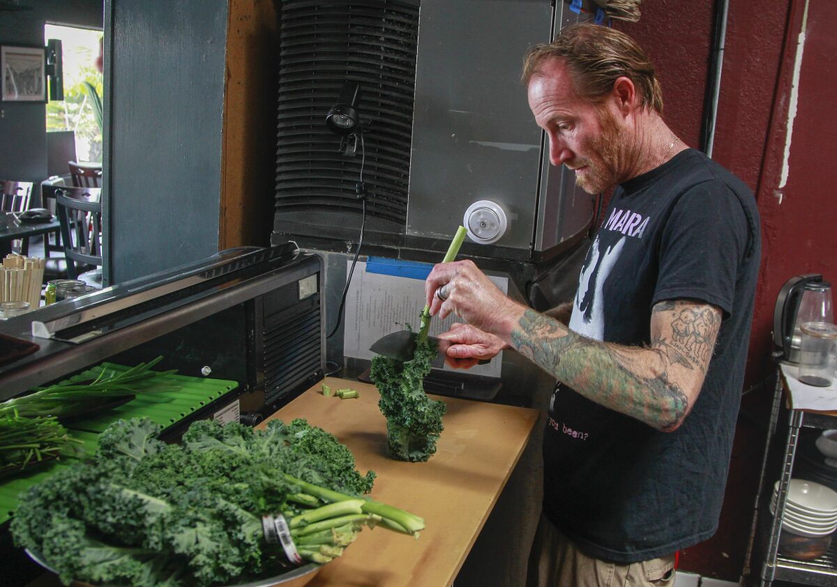Chef Davin Waite cleans kale at his Wrench & Rodent Seabasstropub in Oceanside.
