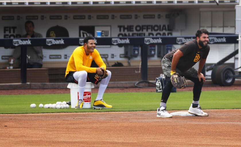 Manny Machado keeps his distance while watching Eric Hosmer field balls at Petco Park on March 23. The pair could join teammates and coaches for spring training at the ballpark in June.