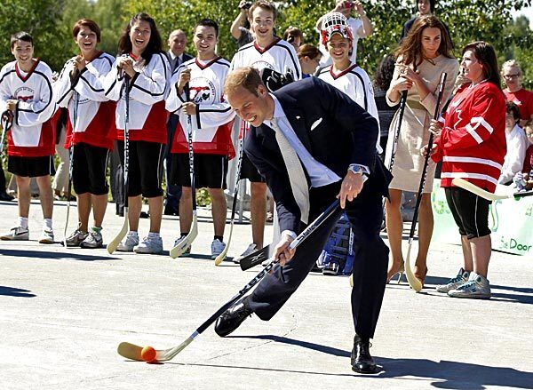 Catherine, Duchess of Cambridge, watches as Prince William makes a shot during a game of street hockey in Yellowknife, Northwest Territories.