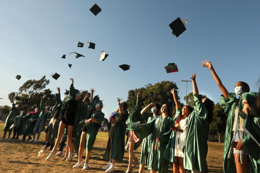 LOS ANGELES, CA - JUNE 10, 2020 - - The graduating Class of 2020 from the New West Charter School toss their caps in the air at Stoner Park in Los Angeles on June 10, 2020. The drive-by graduation ceremony happened a few blocks away from the park at the charter school. The graduation ceremony was suppose to take place at UCLA but due to the coronavirus pandemic had to revert to a drive-by graduation at the charter school. The hat toss was organized by graduate Sage Rousso-Schindler. (Genaro Molina / Los Angeles Times)