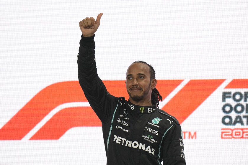 Lewis Hamilton de la escudería Mercedes celebra en el podio su victoria en el Gran Premio de Qatar, el domingo 21 de noviembre de 2021. (AP Foto/Darko Bandic)