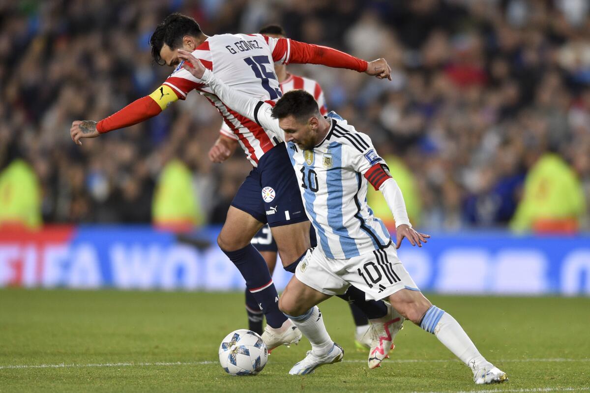 El argentino Lionel Messi pelea por el balón con el paraguayo Gustavo Gómez 