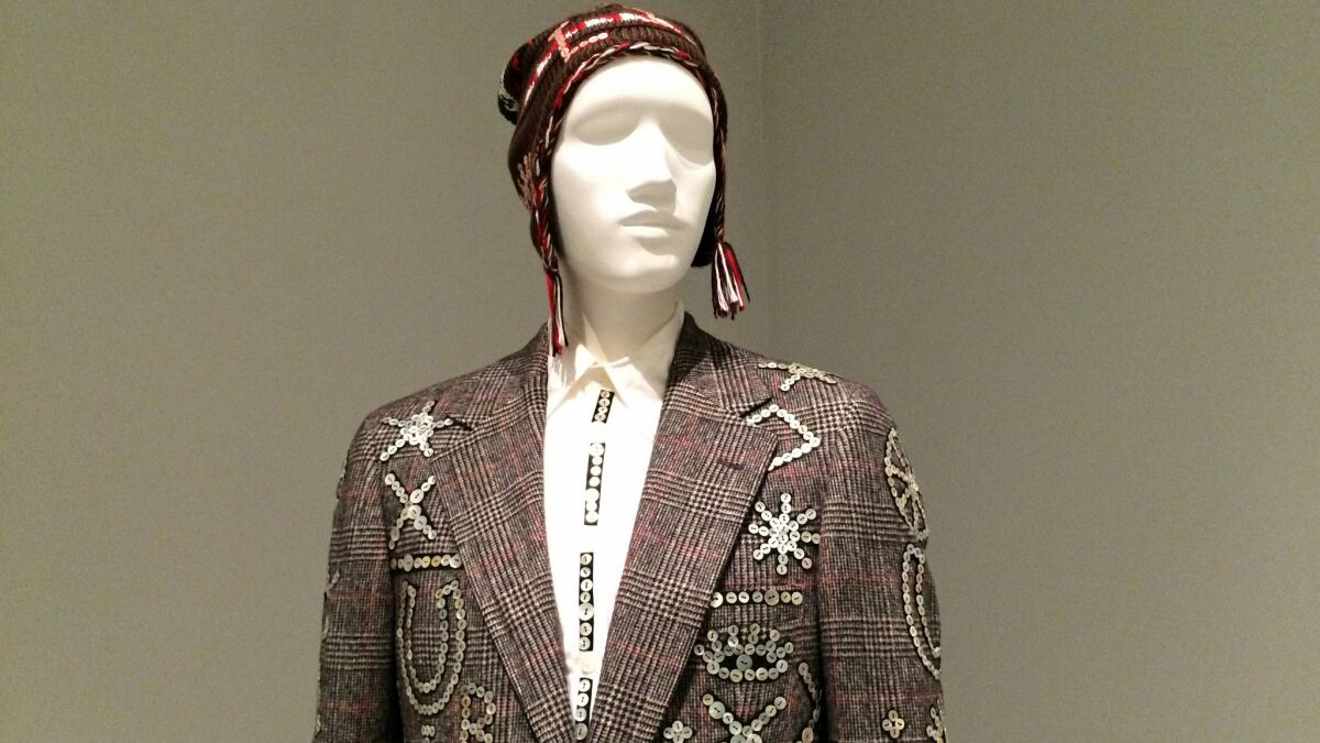 Johnson Hartig's 2012-13 suit for the label Libertine is a contemporary nod to England's Pearly Kings and Queens, working class figures who wear ensembles adorned with shimmering mother of pearl buttons.