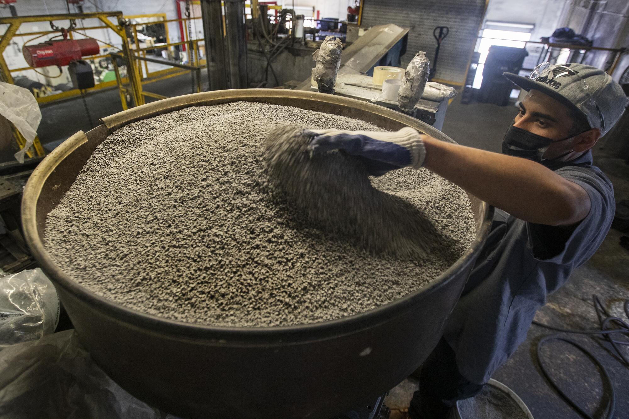 Jonathan Contreras, 28, adds gray coloring, to be mixed in with ground up rubber to make rubber tiles.