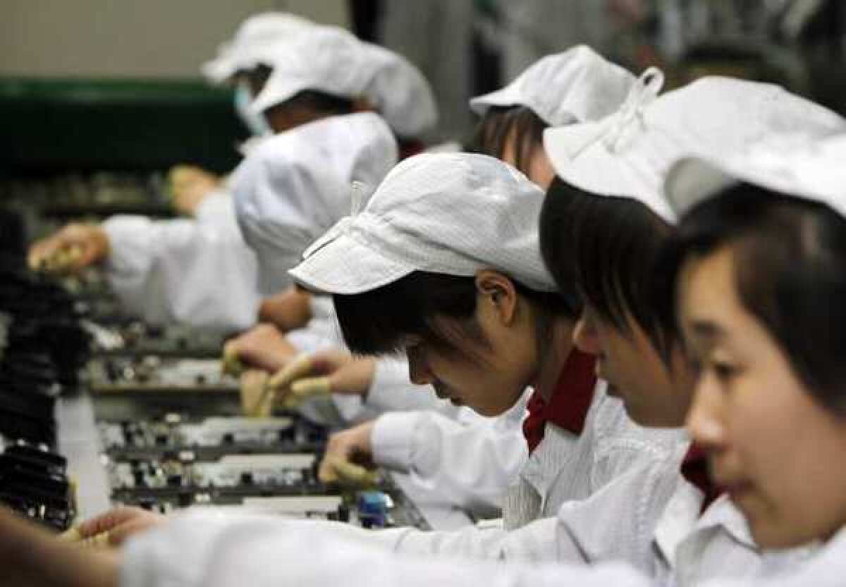 Staff members work on the production line at the Foxconn complex in the southern Chinese city of Shenzhen. The company manufactures Apple's iPhones and iPads.