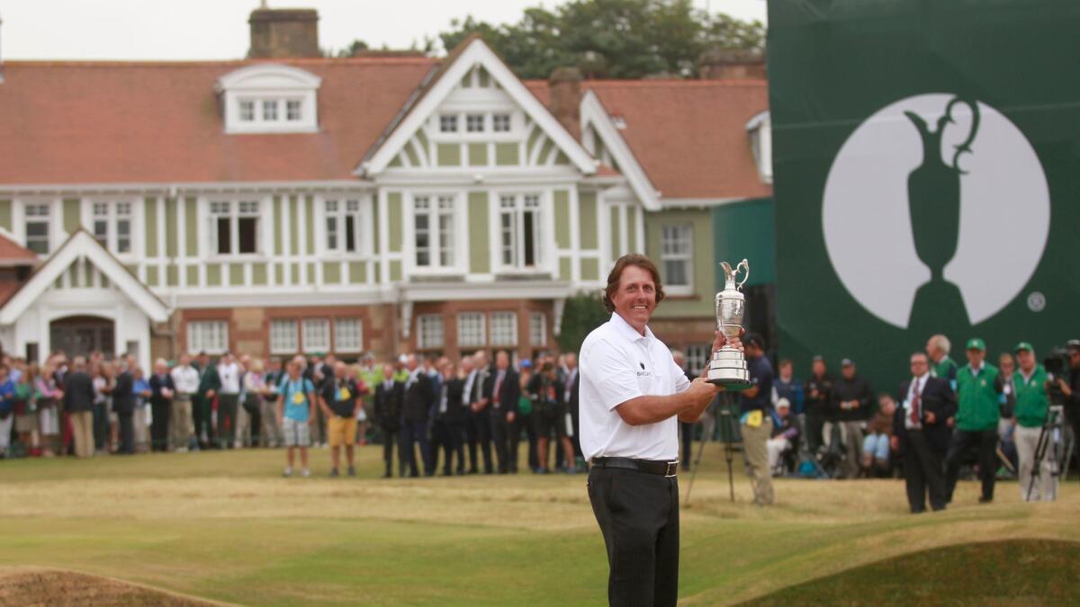 Phil Mickelson holds up the Claret Jug trophy after winning the British Open at Muirfield on July 21, 2013.