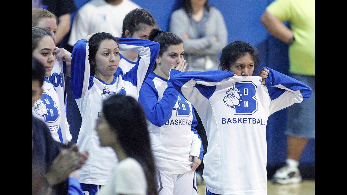 Players on the Burbank High girls' basketball team watch in disbelief during the closing seconds of their game against rival Burroughs, watching a 4-point lead evaporate at the Burroughs free throw line.