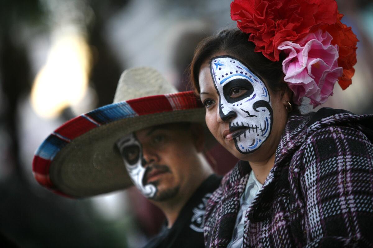 Their faces freshly painted, Emeyda and Alberto Matinez joined others watching Day of the Dead celebrations at the square on Olvera Street in downtown L.A.