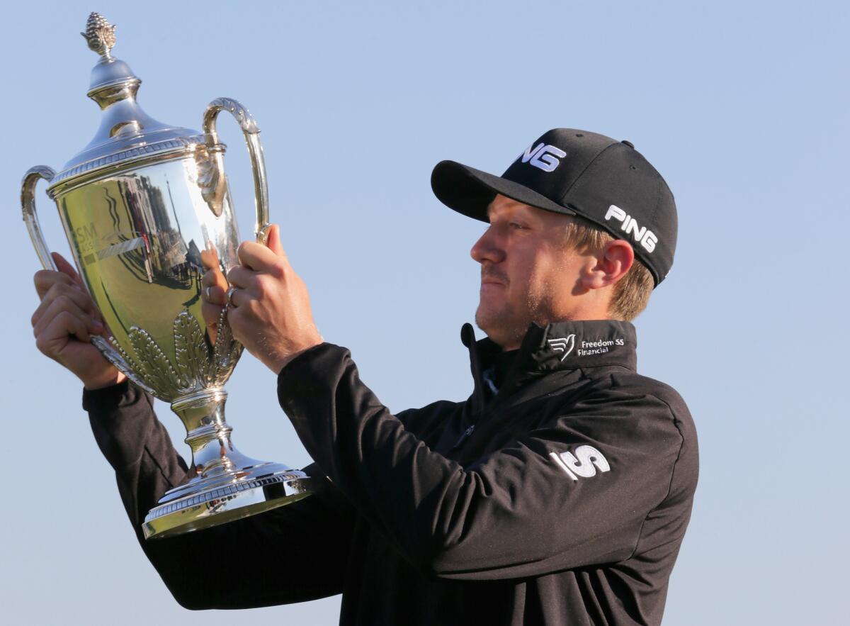 Mackenzie Hughes poses with his trophy after winning the playoff of the final round of the RSM Classic on Nov. 21.