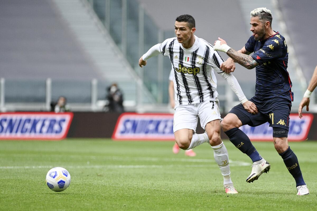 Juventus' Cristiano Ronaldo, right, vies for the ball with Genoa's Valon Behrami during the Serie A soccer match between Juventus and Genoa, at the Turin Allianz stadium, Italy, Sunday, April 11, 2021. (Marco Alpozzi/LaPresse via AP)