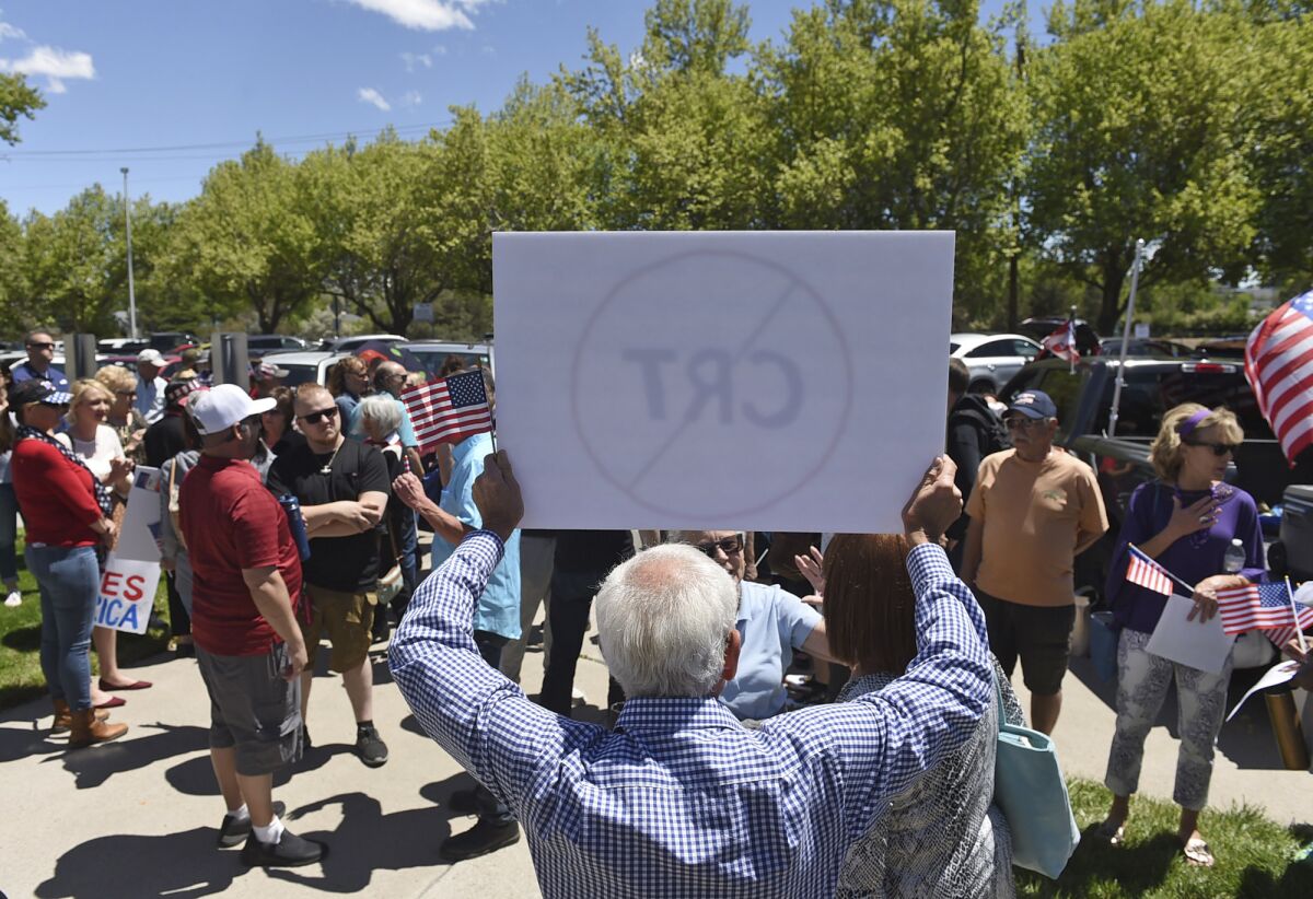FILE - In this May 25, 2021, file photo, a man holds up a sign against Critical Race Theory during a protest outside a Washoe County School District board meeting in Reno, Nev. Developed in the 1970s and '80s, critical race theory is a way of thinking about America’s history through the lens of racism. It centers on the idea that racism is systemic in the nation’s institutions and that they function to maintain the dominance of whites. (Andy Barron/Reno Gazette-Journal via AP, File)
