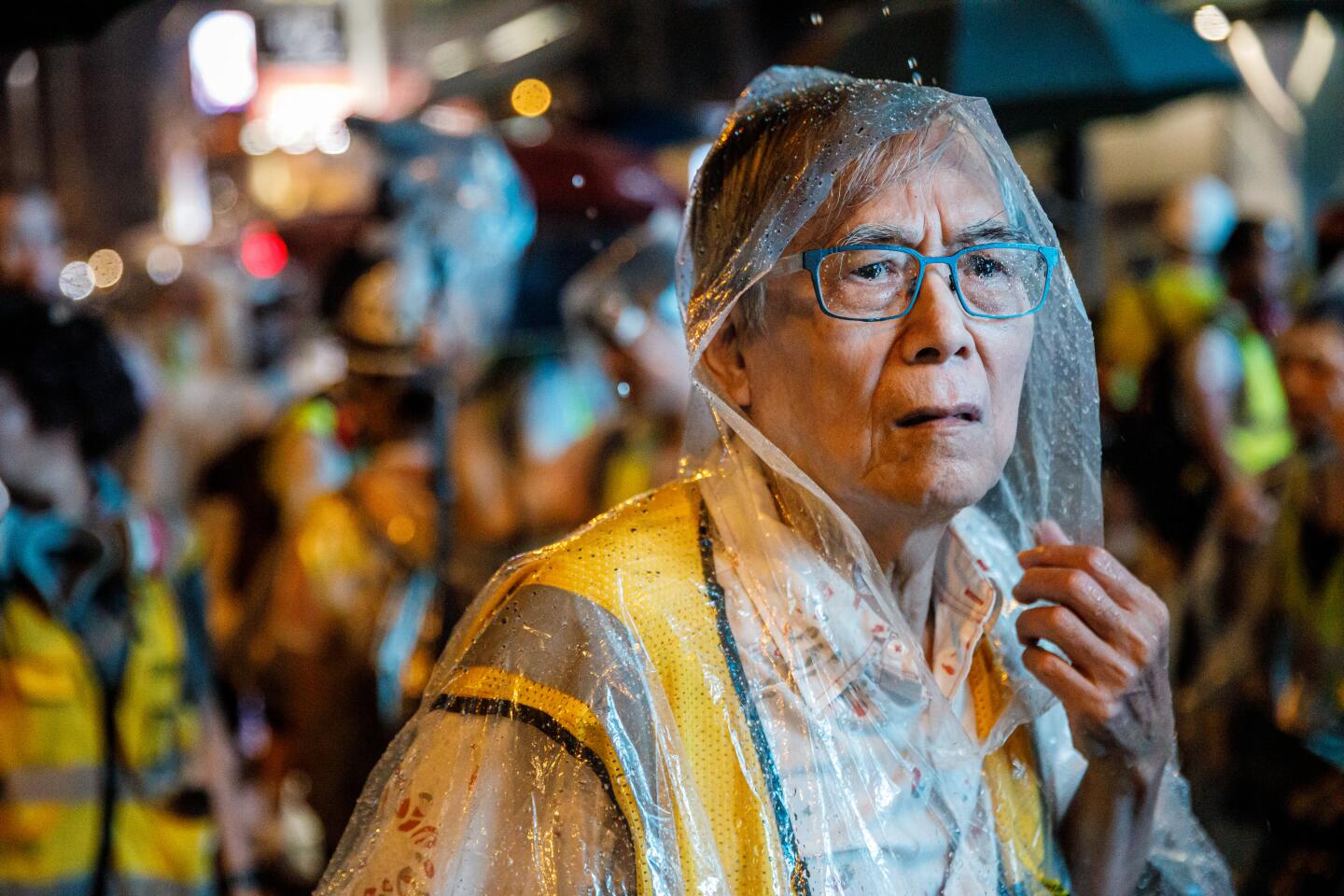 Uncle Wong, a member of the Protect the Children, a community group who put themselves between the police and young protesters against the government, looks carefully down Nathan road for police presence.