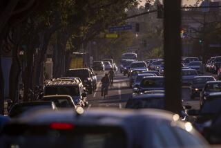 West Hollywood, CA - October 28: People on bikes ride in the bike lane as traffic stacks up along Santa Monica Blvd. in West Hollywood at sunset Thursday, Oct. 28, 2021. (Allen J. Schaben / Los Angeles Times)