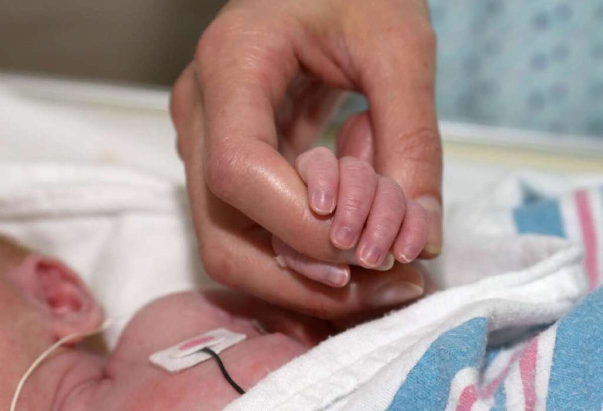 A doctor holds an infant's hand at Duke University Medical Center in Durham, N.C. Vital statistics for the U.S. in 2011 were released Monday in a report in the journal Pediatrics.