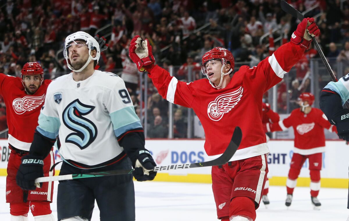 Detroit Red Wings right wing Lucas Raymond (23) celebrates his goal as Seattle Kraken center Marcus Johansson (90) reacts during the third period of an NHL hockey game Wednesday, Dec. 1, 2021, in Detroit. The Red Wings defeated the Kraken 4-3 in a shootout. (AP Photo/Duane Burleson)