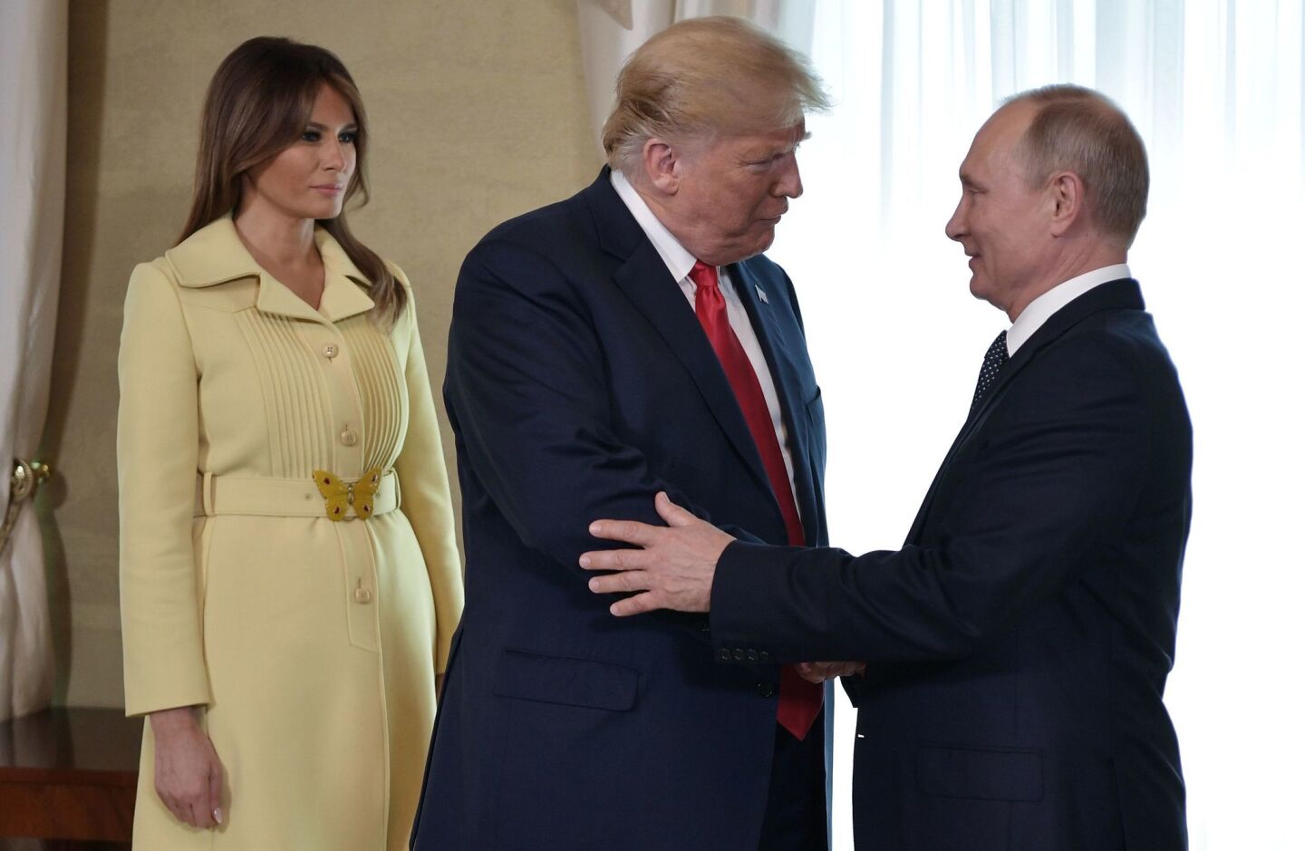 President Trump shakes hands with Russia President Vladimir Putin next to First Lady Melania Trump ahead of a meeting in Helsinki, Finland.