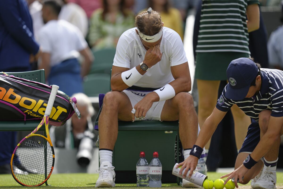 Rafael Nadal sits with head bowed during an injury break in his quarterfinal match.