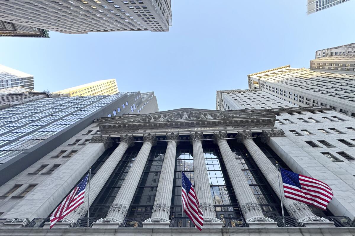Three U.S. flags hang from the New York Stock Exchange.