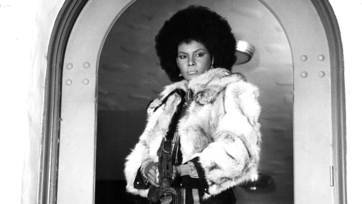 Tamara Dobson holds a gun in the doorway in a scene from the film "Cleopatra Jones."