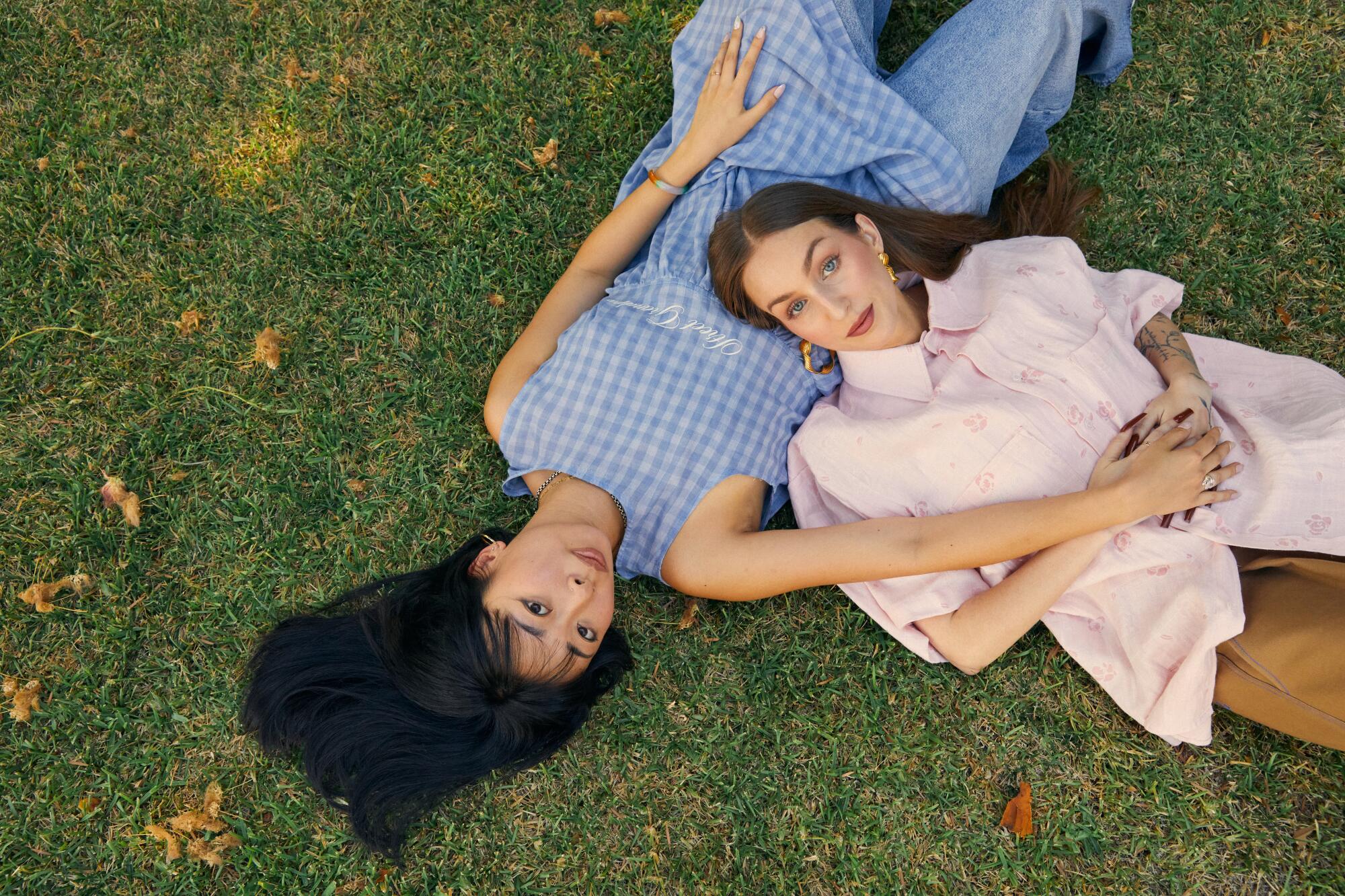Andrea Cheung and Devin Perry lay in the grass wearing clothing from their brand, Street Grandma.