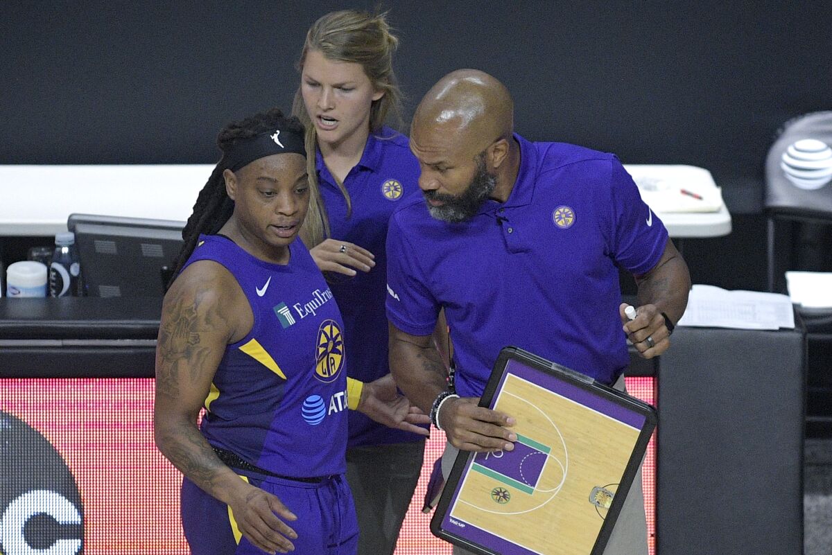 Sparks guard Riquna Williams talks strategy with coach Derek Fisher during a game against the Fever on Saturday.