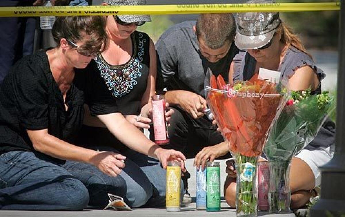 From left, Debbie, Donna, Erik and Silvia Krecu light candles and place flowers outside a San Clemente condo where their friend was found badly beaten; she later died. John Wylie Needham, 25, the victim's boyfriend and an Army veteran, has been arrested in connection with the slaying.