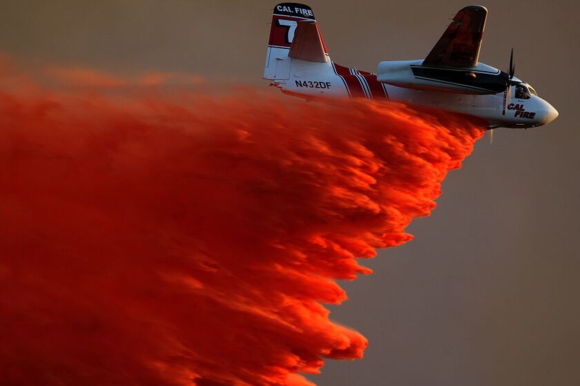 SAN MARCOS, CA.-MAY 14, 2014: A Cal Fire airplane makes a fire retardant drop on brush near Cal State San Marcos as crews battle a large wildfire threatening homes in San Marcos Wednesday, May 14, 2014. (Allen J. Schaben/Los Angeles Times)