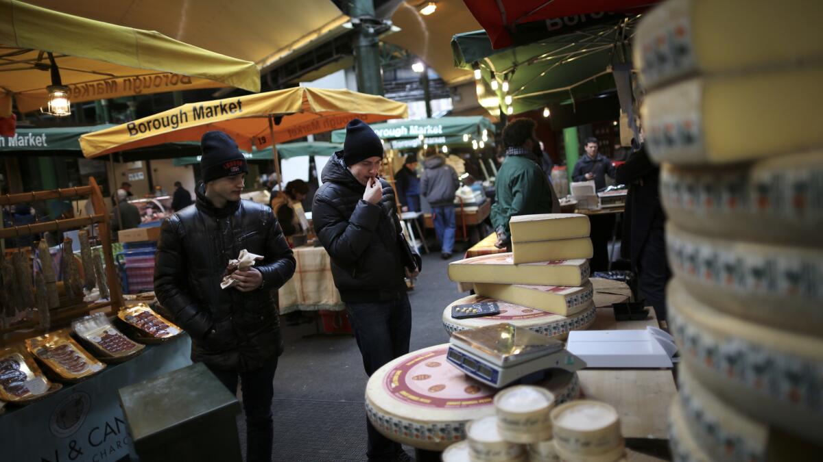 Customers try a free sample of cheese at Borough Market in London.