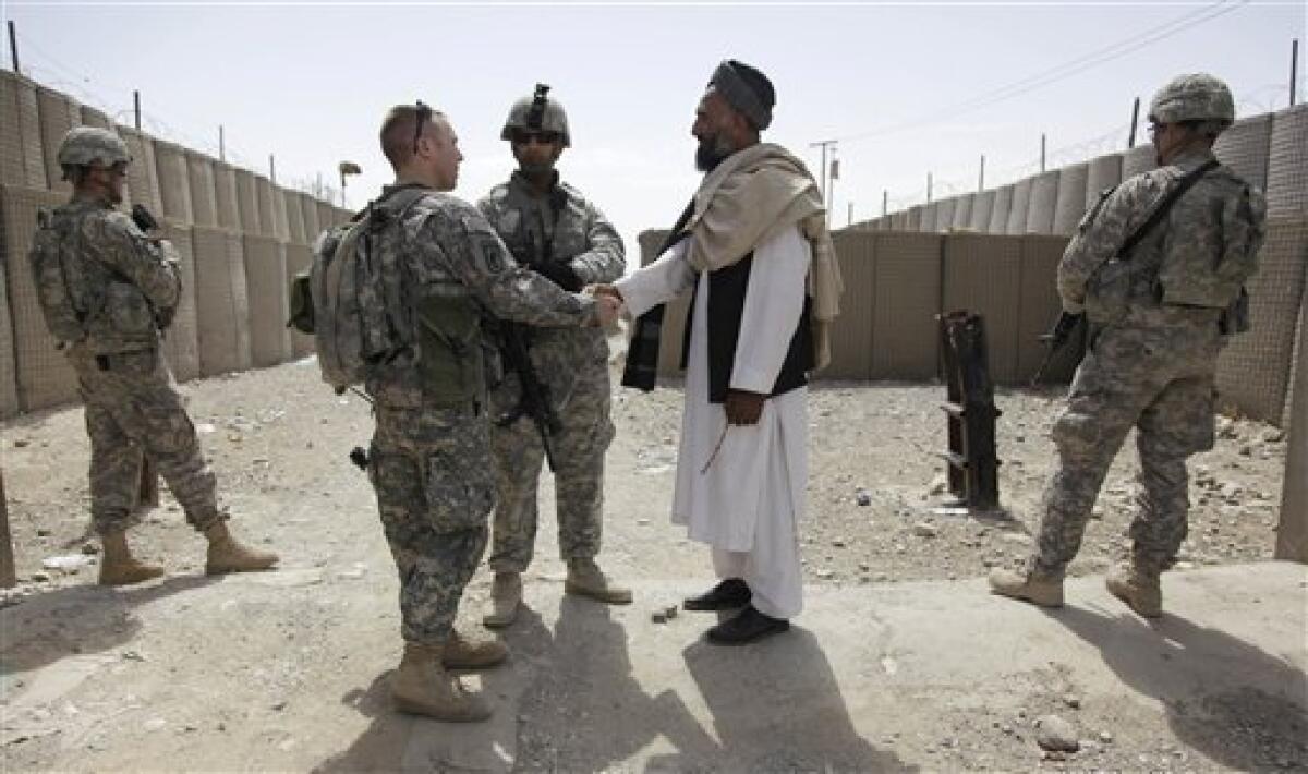 In this April 29, 2010 photo, Sher Mohammed, right center, talks with U.S. Army Capt. Casey Thoreen, left center, of Bravo Company, 2nd Battalion 1st Infantry Regiment of the 5th Stryker Brigade, 2nd Infantry Division, outside the Maiwand district center, in Afghanistan's Kandahar province. Mohammed's 25-year-old brother was shot and killed in mid-March by a private Afghan security company escorting a NATO convoy. Reckless behavior by private Afghan security companies protecting NATO supply convoys in southern Kandahar province is hindering coalition efforts to build local support ahead of this summer's planned offensive in the area, say U.S. and Afghan officials. (AP Photo/Julie Jacobson)