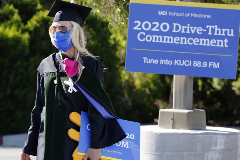 Associate Dean for Students Megan Osborn walks the parking lot before the University of California, Irvine, School of Medicine class of 2020 first ever drive-thru commencement ceremony at the school in Irvine on Saturday, May 30, 2020.
